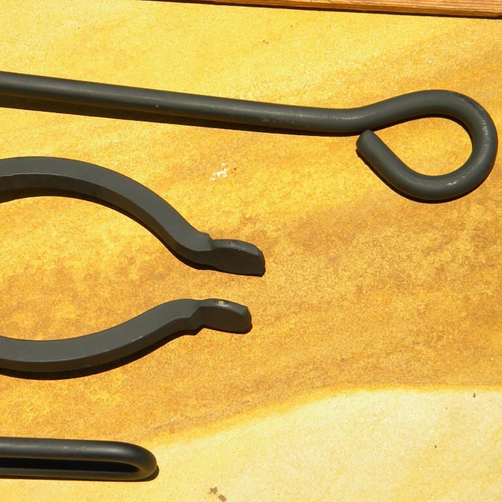 Fire pit tools close-up with curved, pointed ends and black finish