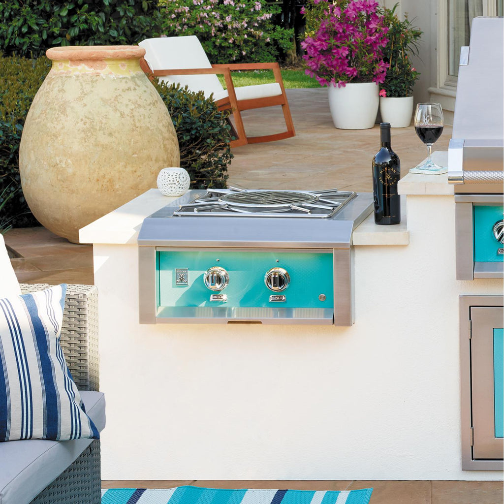 Built-in power burner with turquoise front panel and dual control knobs, stainless grill top.