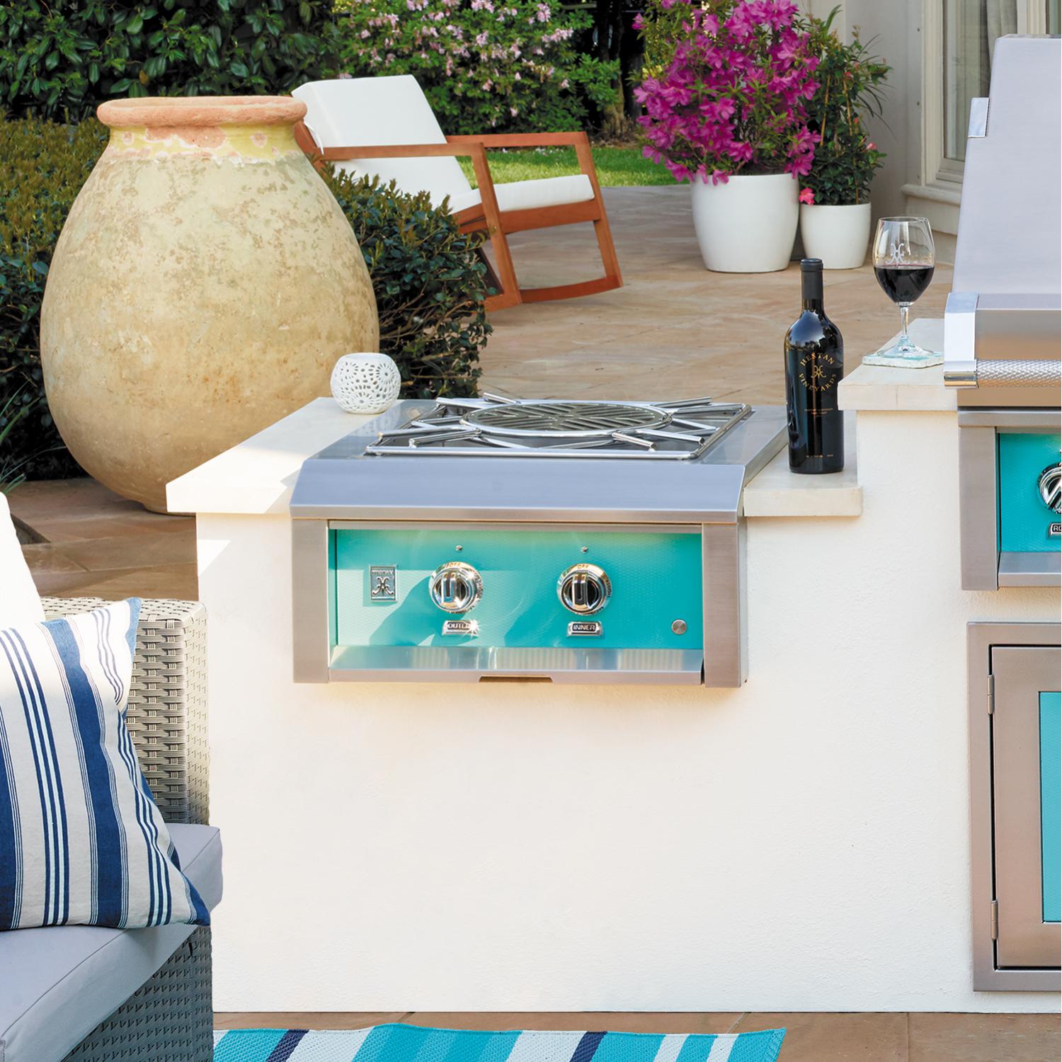 Built-in power burner with turquoise front panel and dual control knobs, stainless grill top.