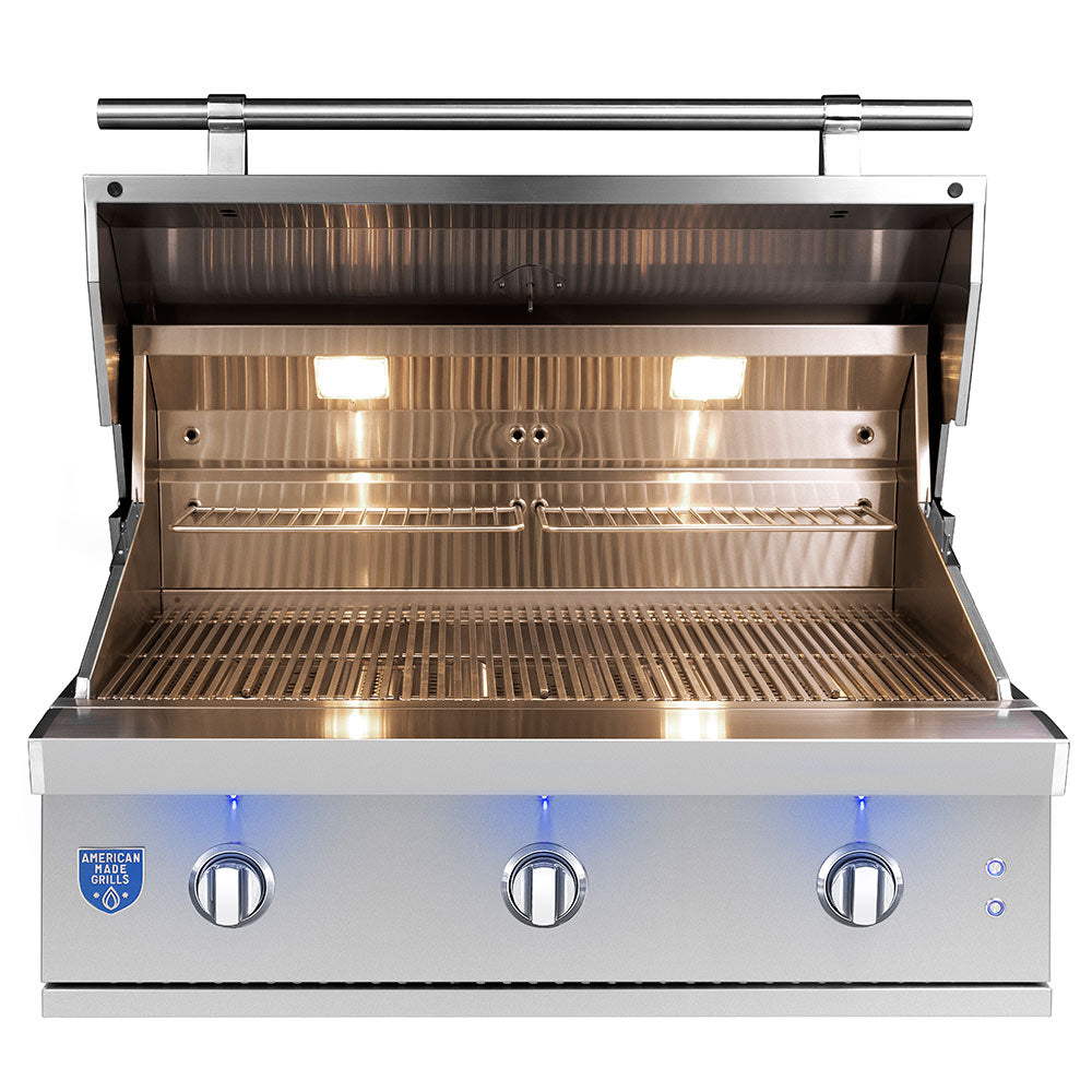 Built-in gas grill with lid open, stainless steel cooking grates and control knobs, warm interior.