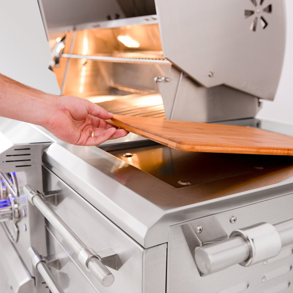 Open grill hood with wooden side shelf and hands adjusting the lid on a freestanding cart