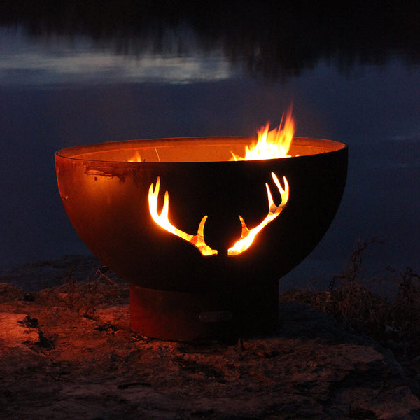 Antler-themed gas fire pit bowl with flames, dark rust patina finish