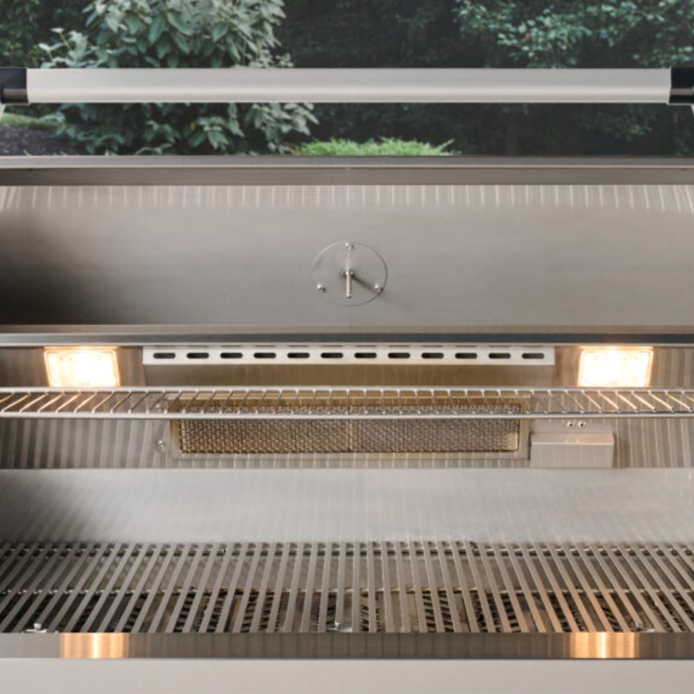 Open built-in gas grill interior with rear burner tray and warming rack
