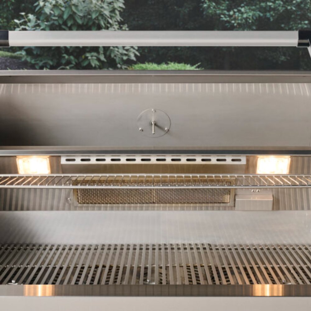 Built-in gas grill interior with empty stainless grates and heat shield back panel