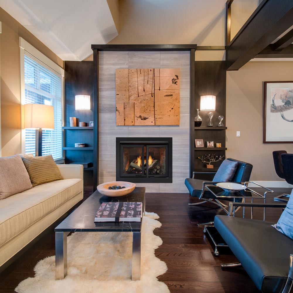 Installed fireplace with black frame and two gray mesh doors, open view