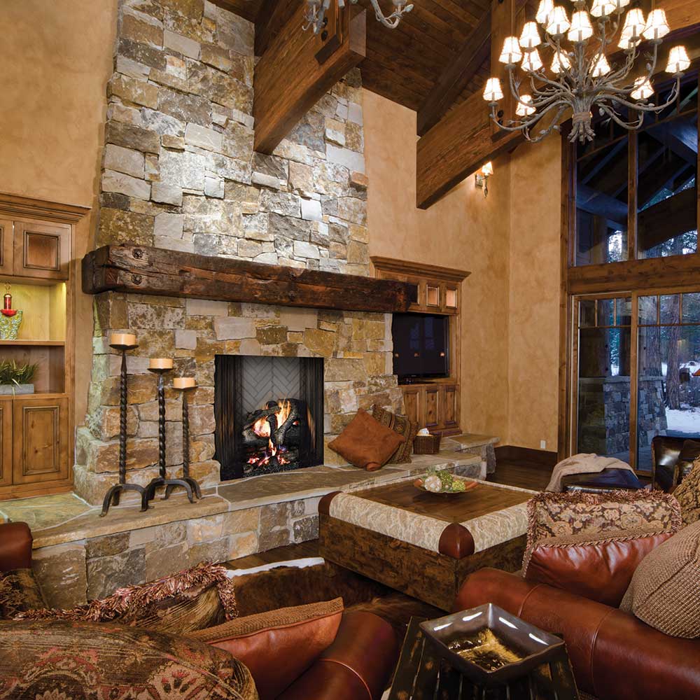 Stone wood-burning fireplace with black firebox, mantel, and tile hearth