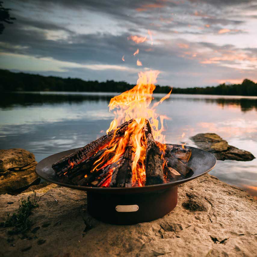 Round wood fire pit bowl with burning logs and bright flames