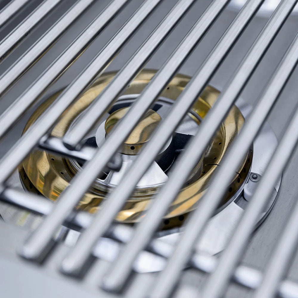 Stainless steel side burner grate with visible burner ports and metal components.