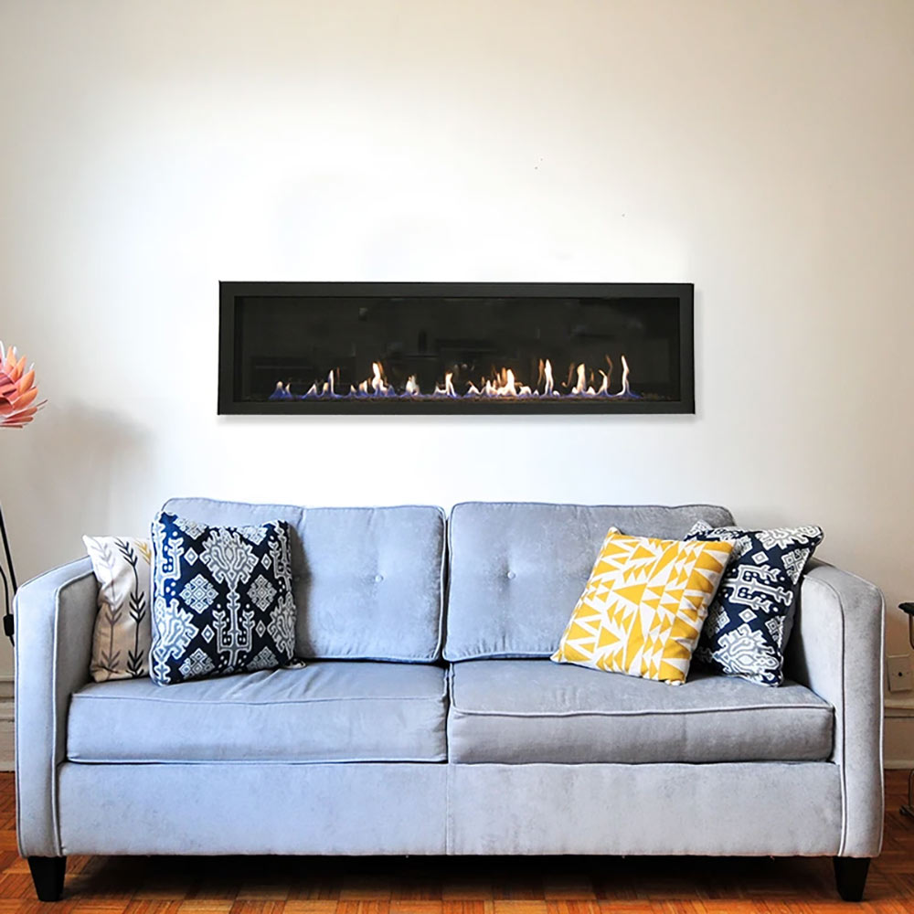 Wall-mounted linear gas fireplace with flames, installed above a light gray sofa.