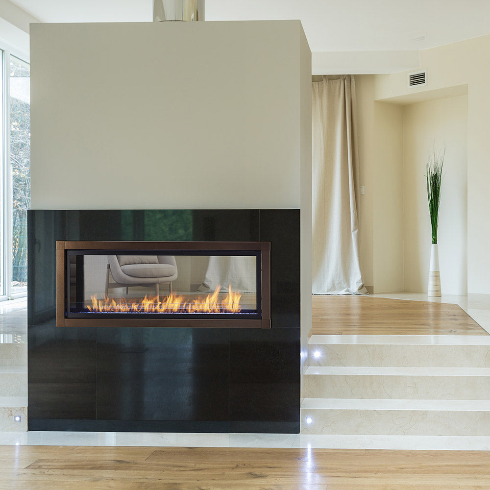Vent-free see-through gas fireplace insert in black surround, flames visible through glass