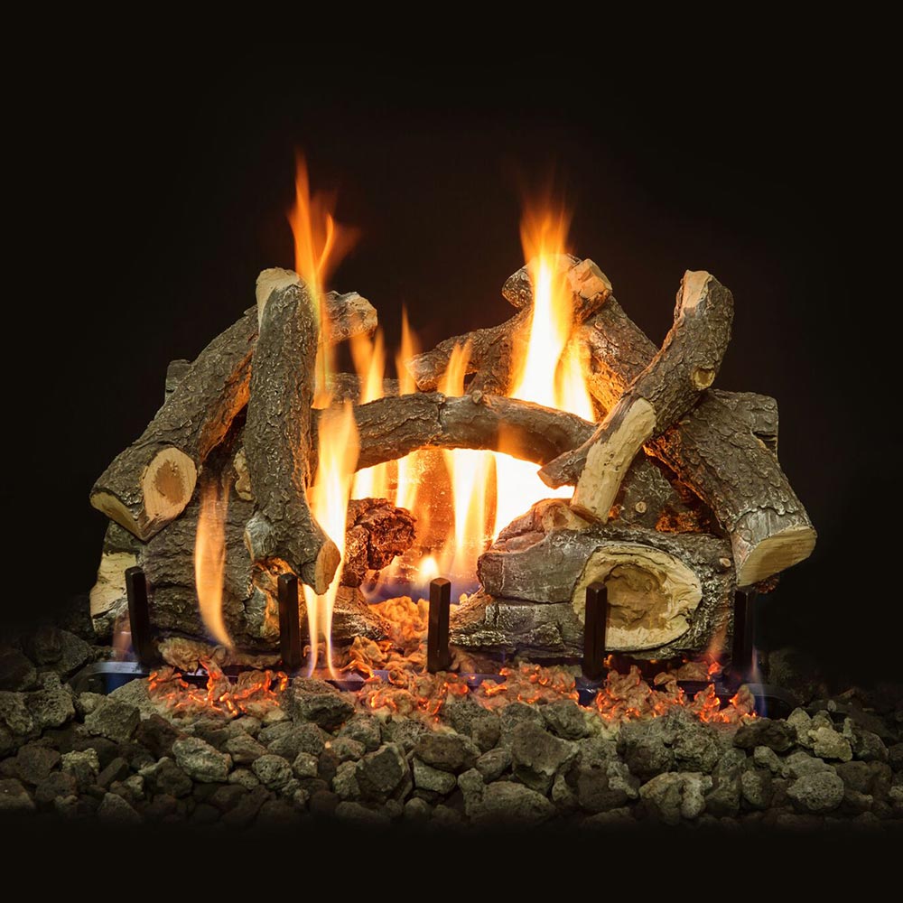 Burning gas log set with stacked charred logs, flames and ember bed on rocks
