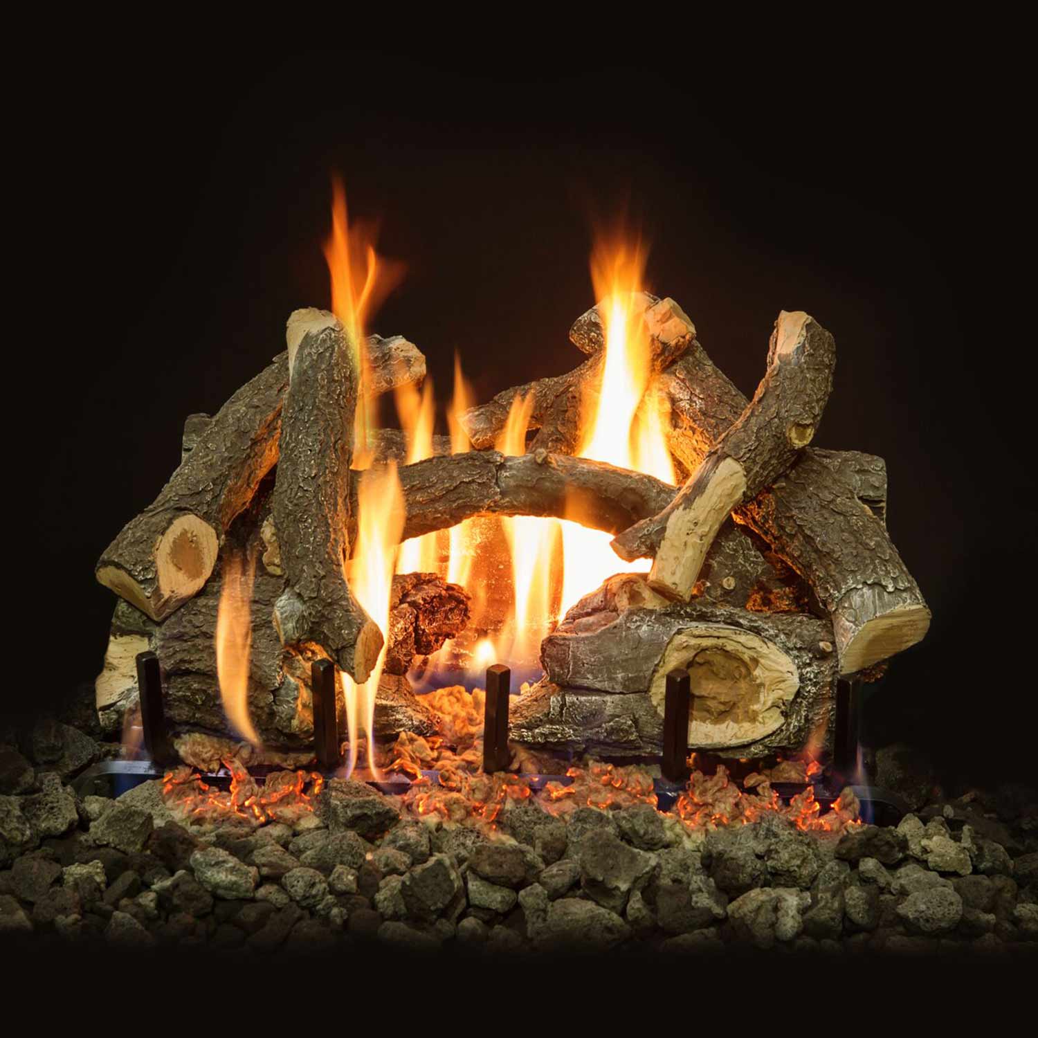 Charred wood gas log set with flames, vented burner logs stacked in a fire ring