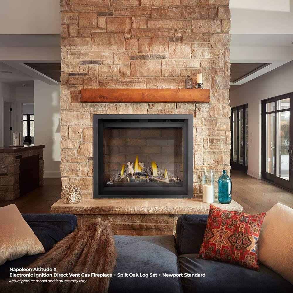 Gas fireplace in stone surround with black frame and burning yellow flames over log set