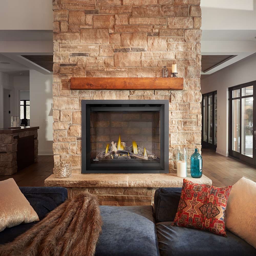 Black gas fireplace insert with burning logs in stone surround