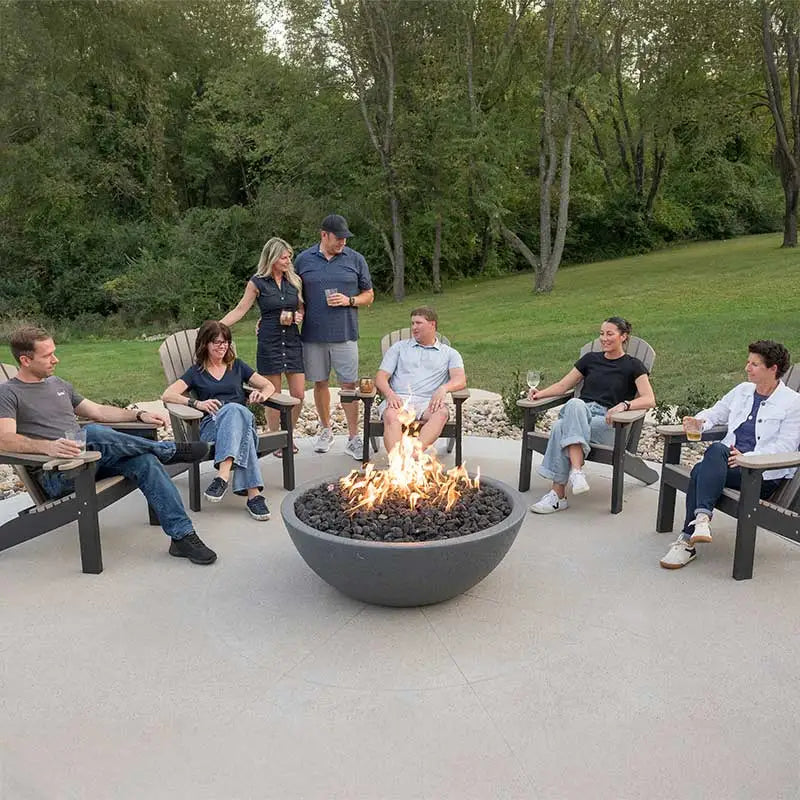 Group of people sitting around a fire pit in a backyard setting