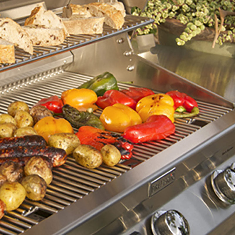 Stainless gas grill grate with assorted grilled foods and red and yellow peppers