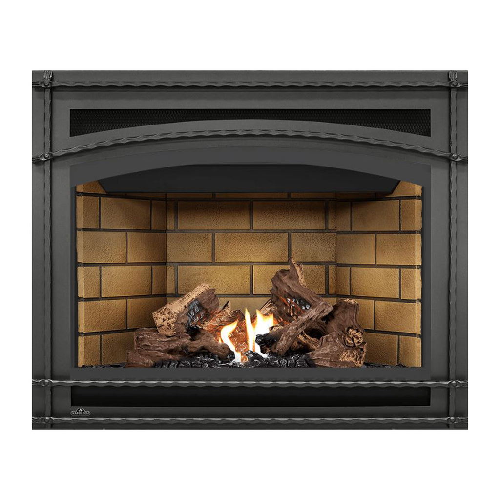 Direct vent gas fireplace with dark frame and burning logs against light tan brick back