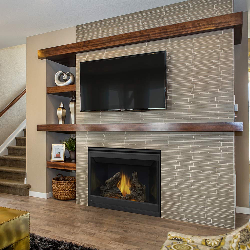 Black direct vent gas fireplace insert in a brick surround with TV above