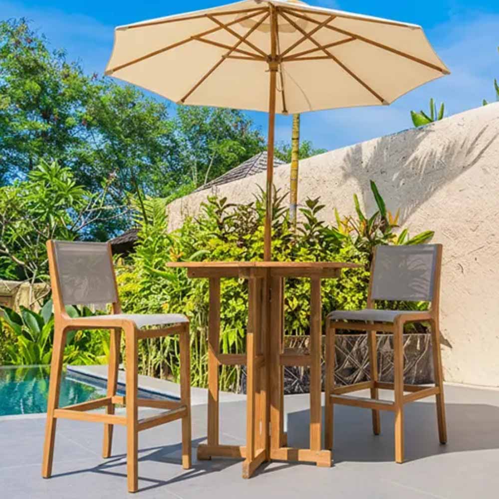 Outdoor teak bar sling chairs with gray fabric seats and backs, under beige umbrella