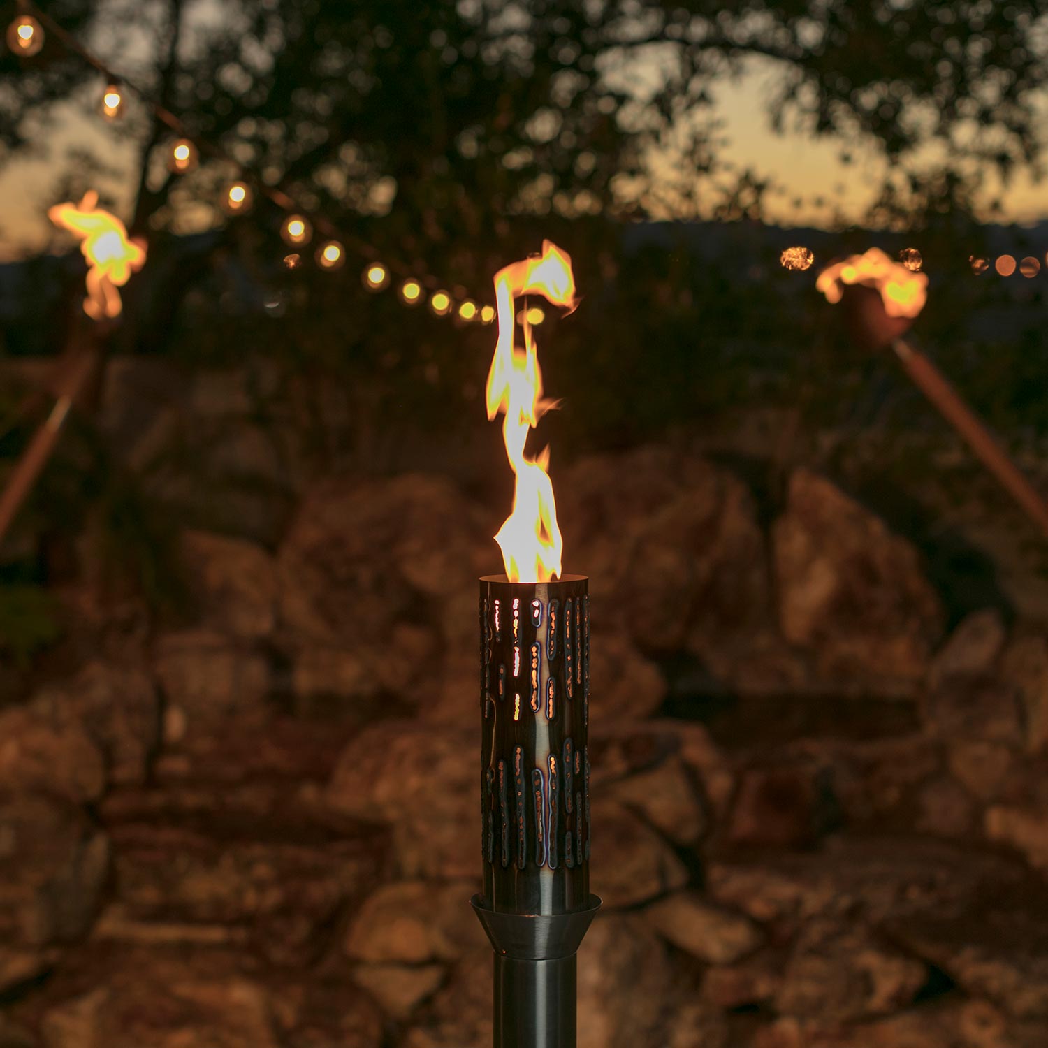 Burning gas torch with perforated cylindrical burner and dark pole