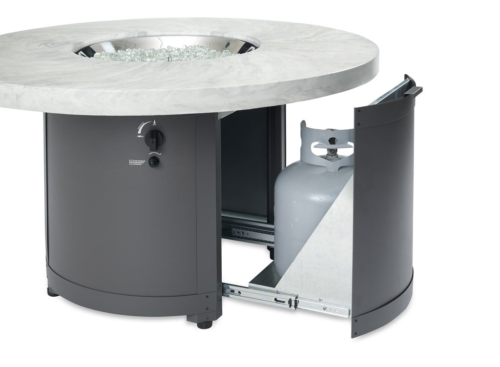 Round fire pit table with light marble top and dark base, side access panel open