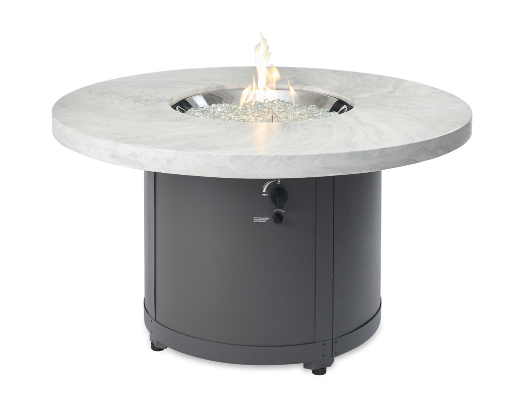 Round fire pit table with light marble top and dark charcoal base, flame in center