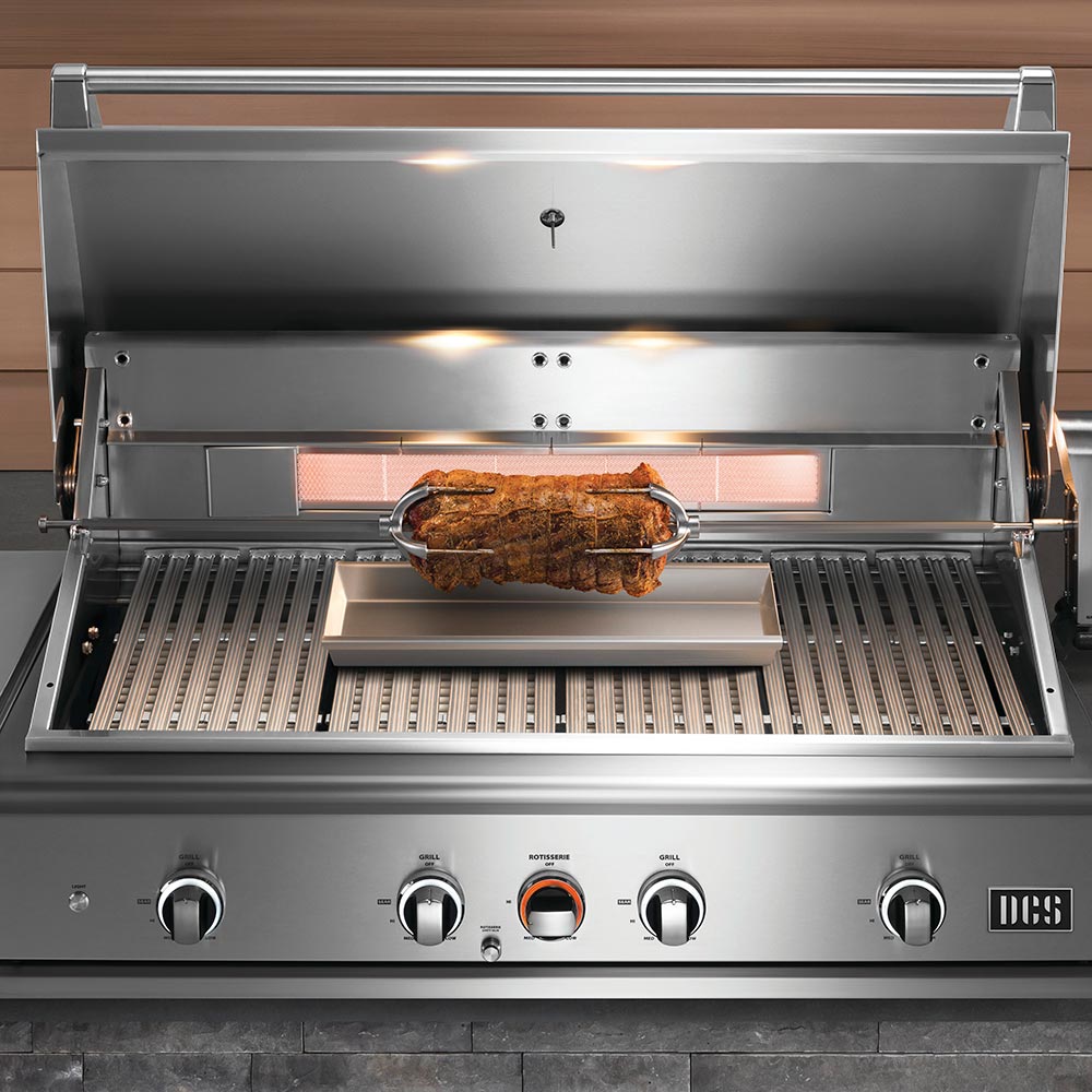 Stainless steel grill with rotisserie system on a wooden background