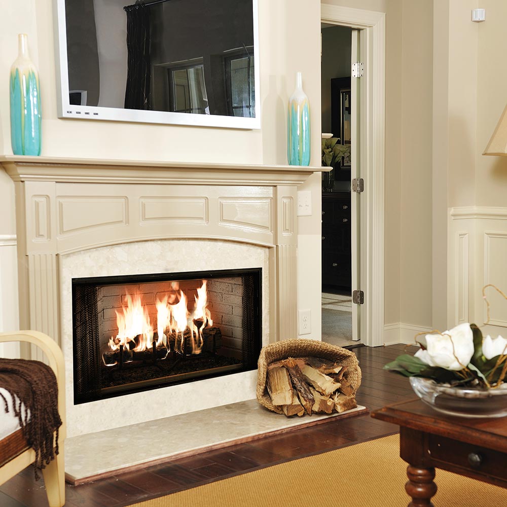 Wood burning fireplace with black firebox glass window, burning logs, and mantel surround