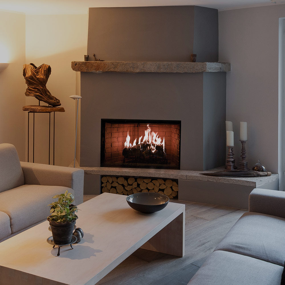 Wood burning fireplace set into gray surround, with visible flames in the brick firebox