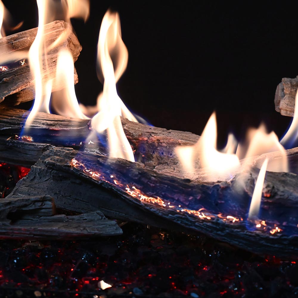Vented gas log set with multiple flames and glowing embers across driftwood-style logs