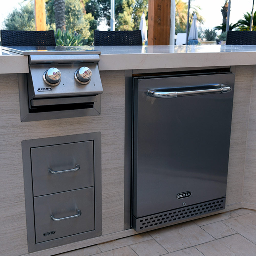 Bull finishing frame on outdoor kitchen refrigerator, with door handle and control knobs