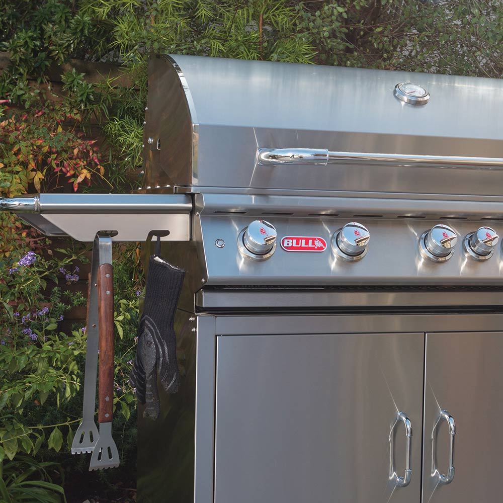 Stainless steel gas grill with side shelves and hanging grill tools