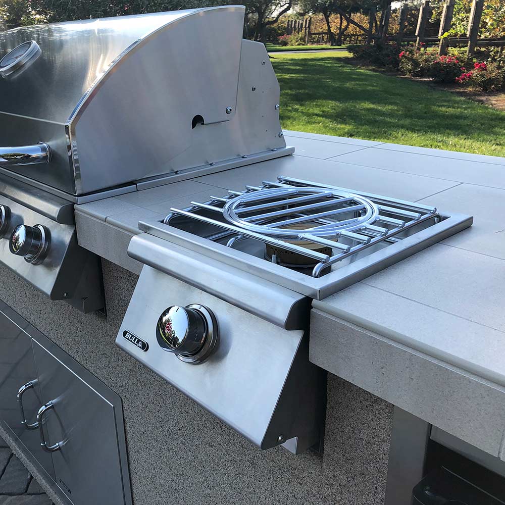 Stainless steel side burner with open lid, grate, and round control knob