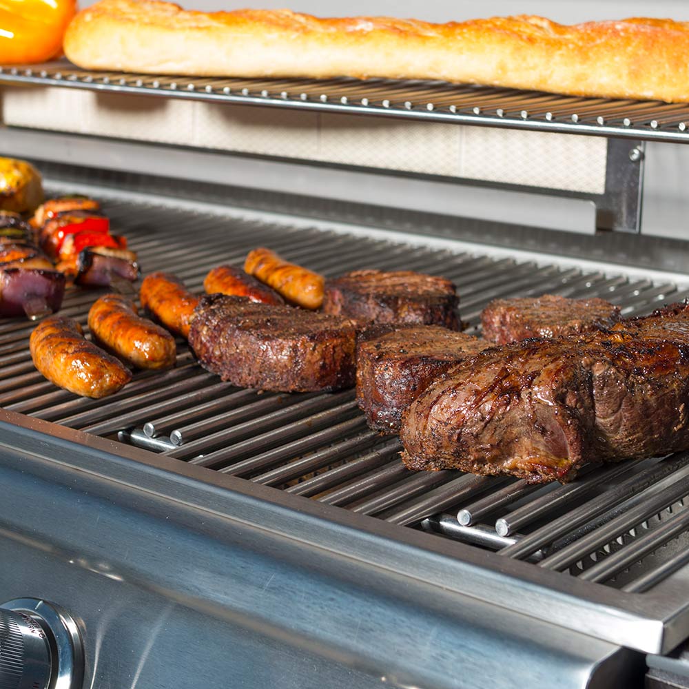 Gas grill grates with grilled sausages and steak slices