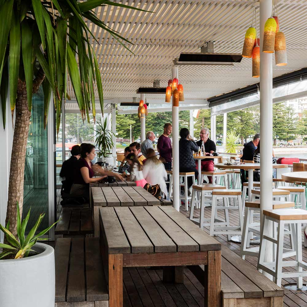Infrared patio electric heater with glowing red elements hanging under outdoor canopy
