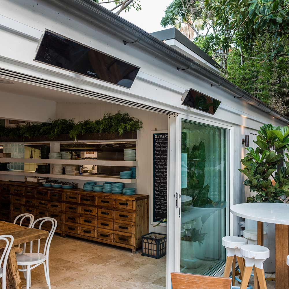 Ceiling-mounted electric heaters with dark rectangular housings and dark glass fronts