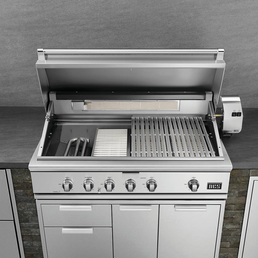 Built-in gas grill with open hood, side handles, and stainless cooking grates