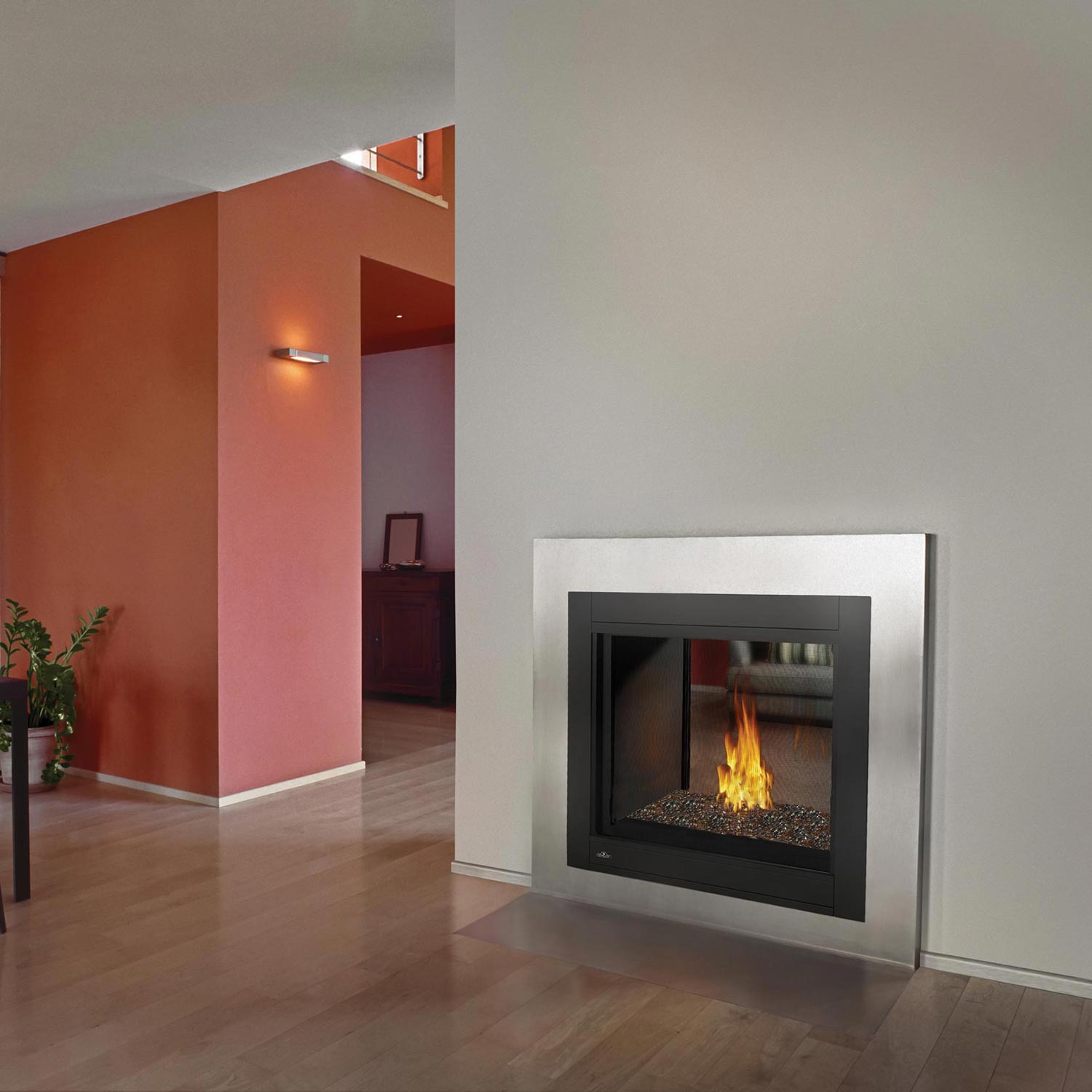 Black framed direct vent gas fireplace with burning logs in the glass-front opening