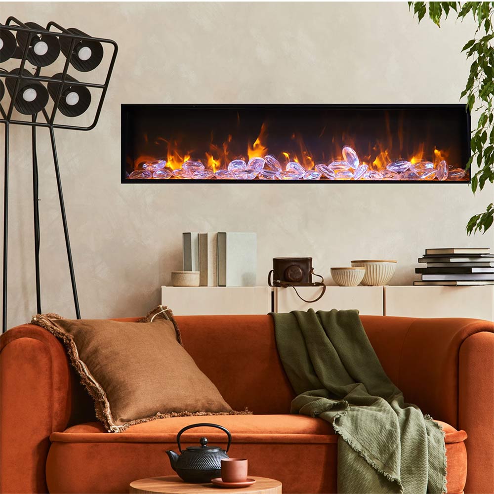 Electric fireplace insert with realistic flame effect and charred logs behind the glass front.