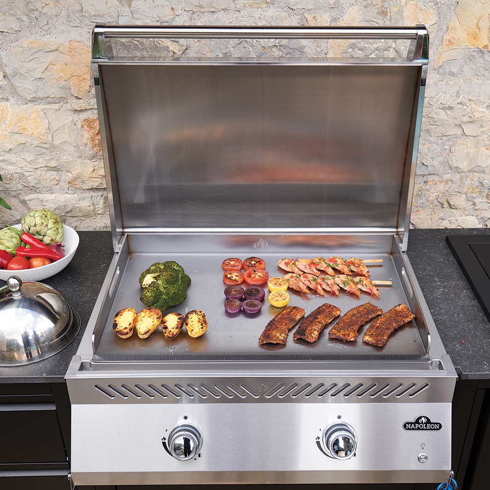 Stainless flat top griddle with open hood and cooked foods on the grill surface