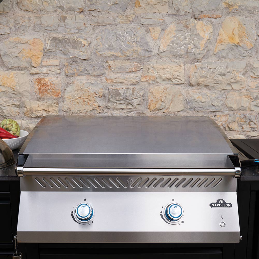 Built-in flat top griddle with closed hood, stainless body, and two control knobs