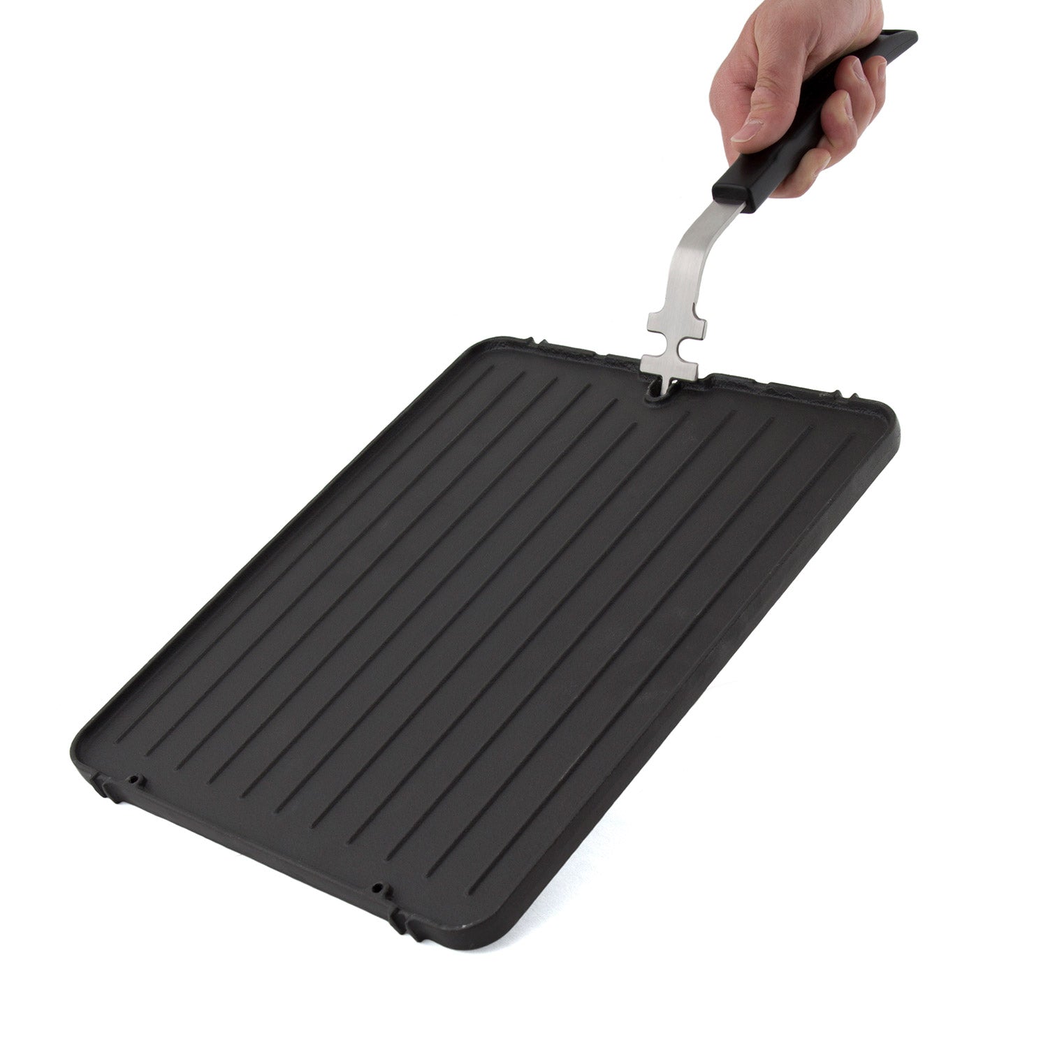 Cast iron griddle insert lifted by a metal handle, ridged cooking surface