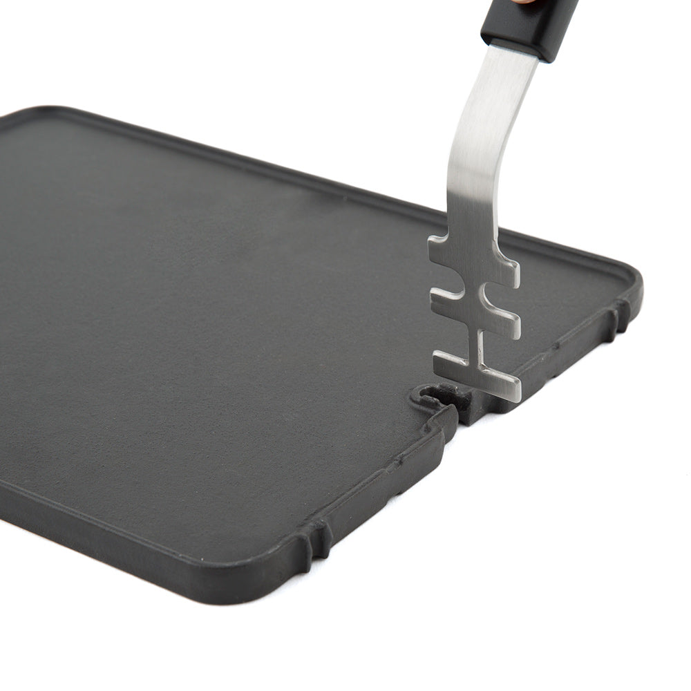 Cast iron griddle insert with handle latch on dark cooking surface