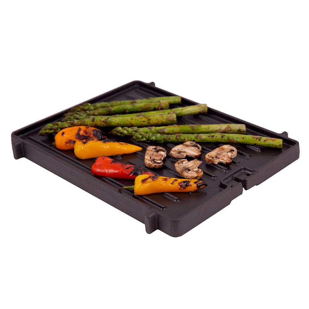 Cast iron griddle with peppers, asparagus, and mushrooms on black surface