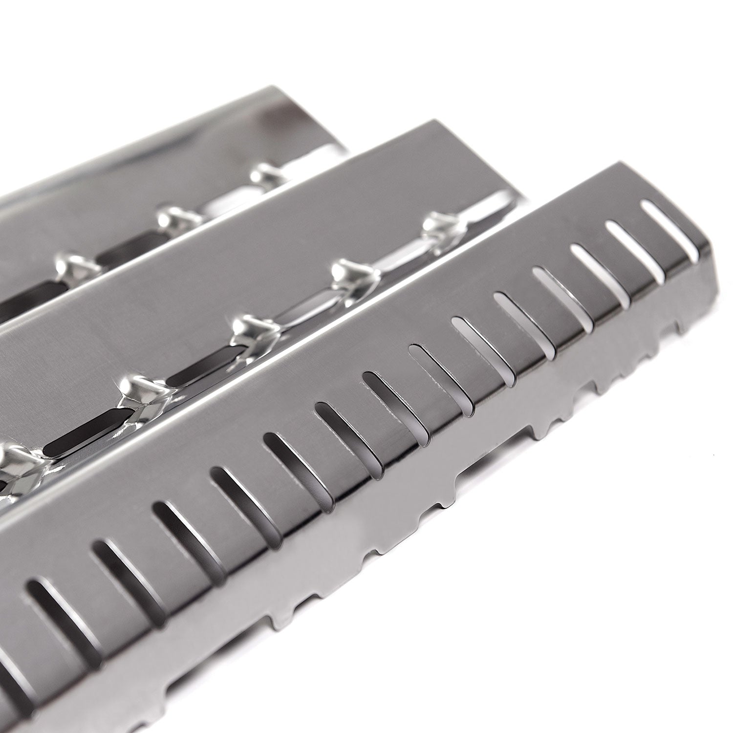 Flame tamer heat deflector with parallel slots and serrated edge
