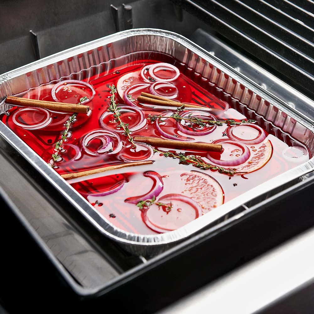 Aluminum drip pan tray with food drippings and herbs, in grill, silver