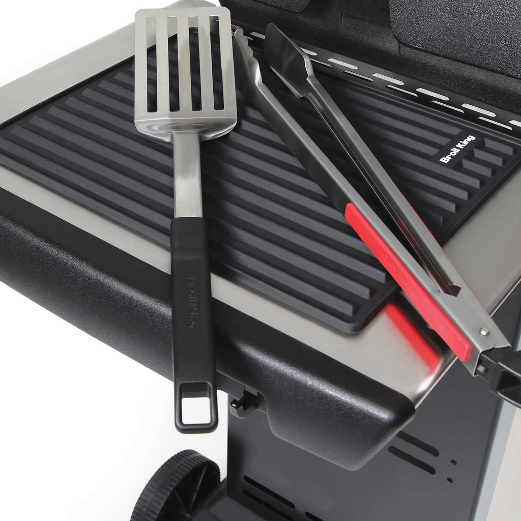 Silicone grill side shelf mat with ridged pattern on grill, with tools on top