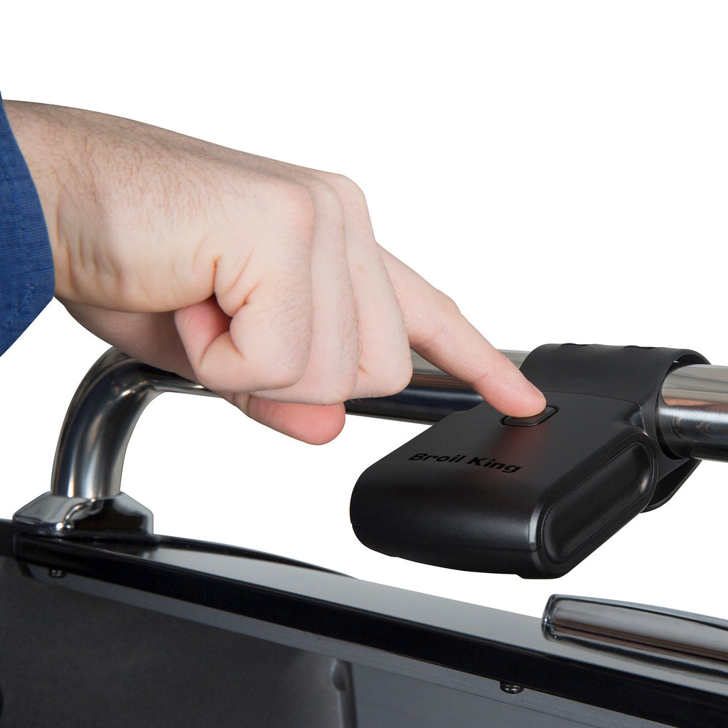 Broil King grill light being positioned on grill frame with a finger on the switch