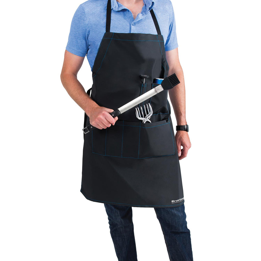 Grilling apron worn over a shirt; black apron with front pockets and built-in tool holder