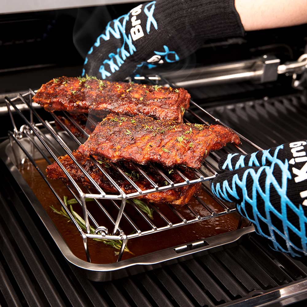 Stainless steel rack holding seasoned meat slabs on the grill grates